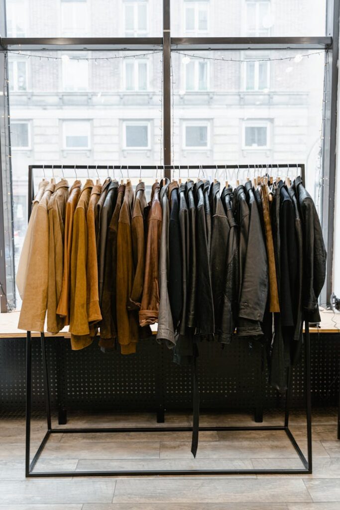 A collection of leather jackets on display in a boutique with glass windows, offering a chic fashion statement.